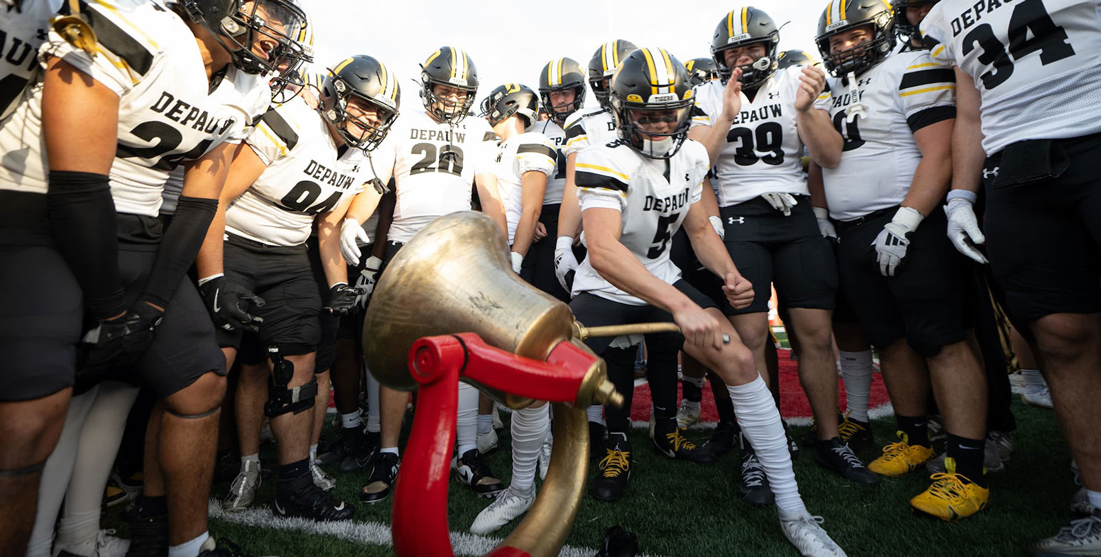 football players rining the monon bell
