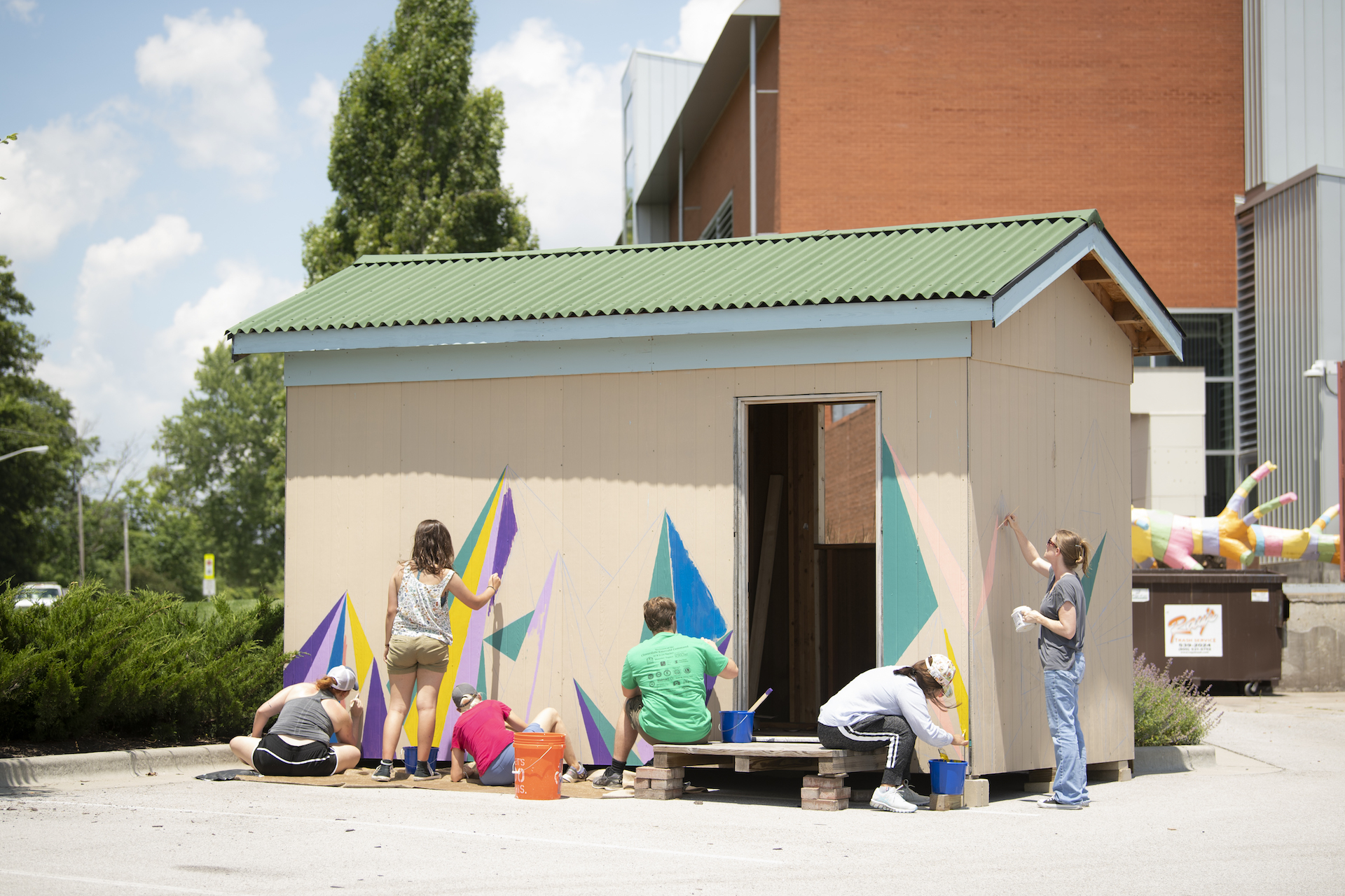 Students painting the side of the plastic shred shed