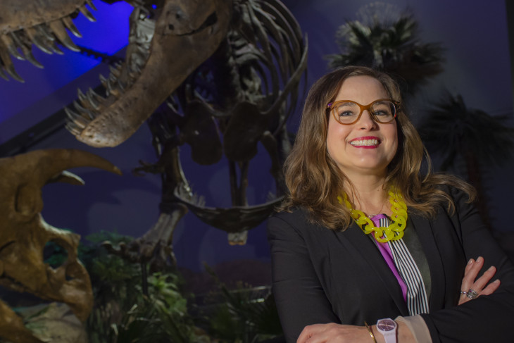 Jennifer Pace Robinson in front of dinosaur fossils