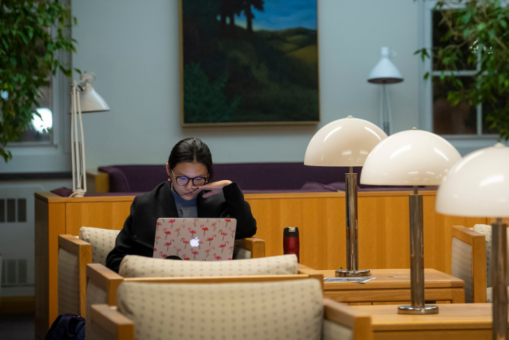 student writing and studying in Roy O West Library