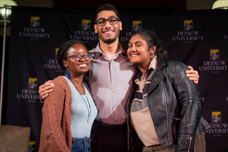 Three students hugging at a university awards ceremony