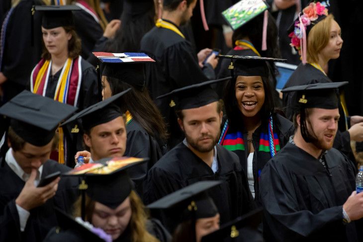 Graduates in caps and gowns celebrate their graduation