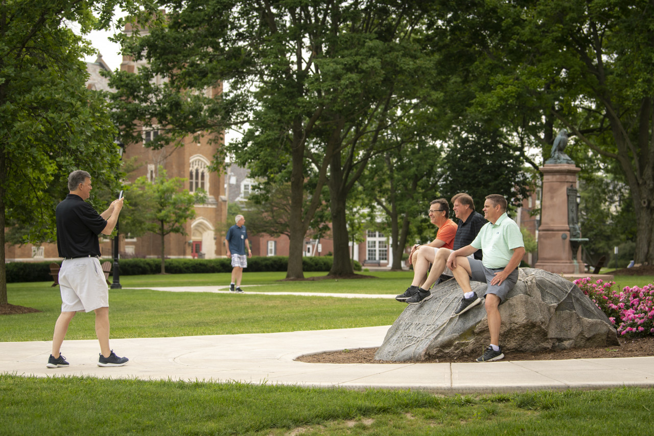 Alumni posing for a photo on the boulder