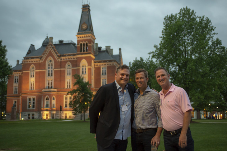 Three friends posing in front of East College