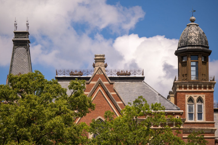 Roofline of East College against a blue sky with clouds