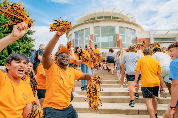 Students cheering in front of the Green Center for Performing Arts