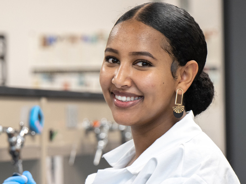 female in lab coat with syringe