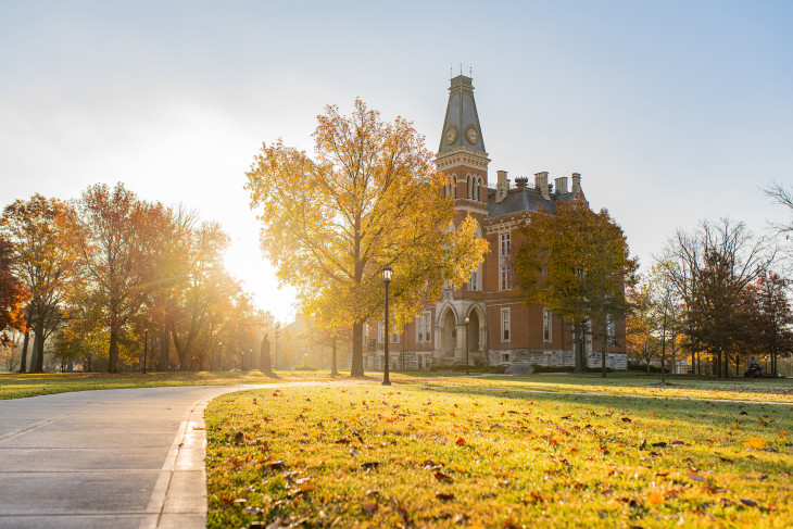 East College with sun shining through trees