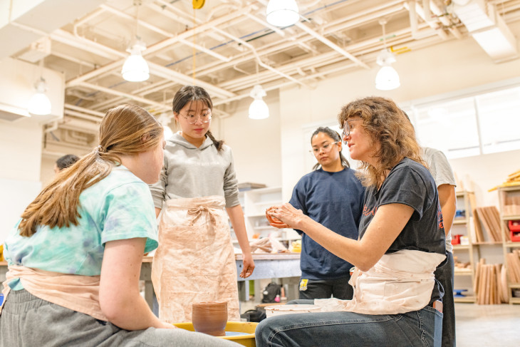Students in a DePauw art studio learning from a professor