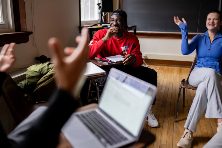 Students in class laughing with arms raised