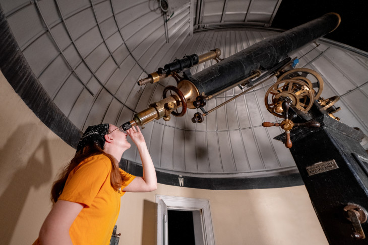 Student looking into a telescope at McKim Observatory