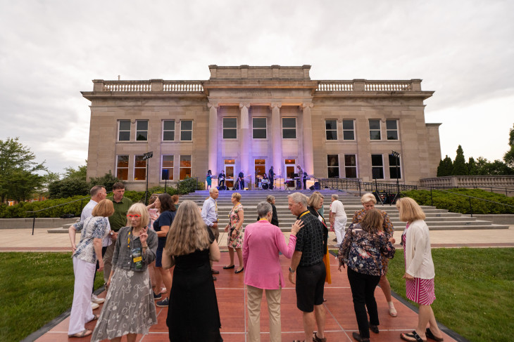 Alumni celebrating Alumni Reunion Weekend in front of the admissions building