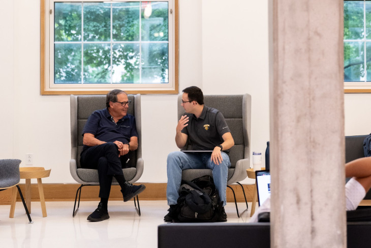 Gary Lemon sits and talks with student