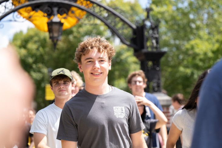 Student Cooper Macy walks beneath arch