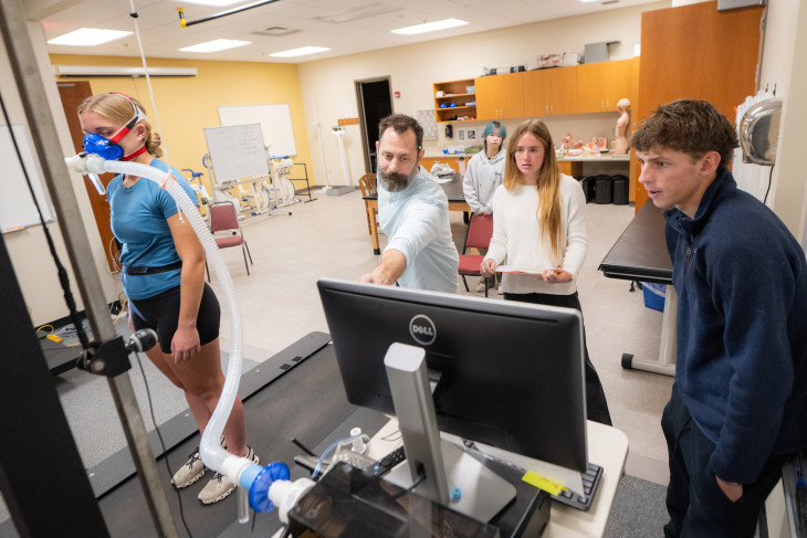 Students and professor in lab conducting research