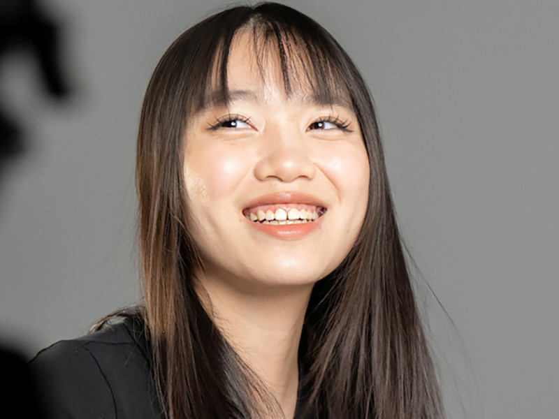 female with black hair smiling for camera