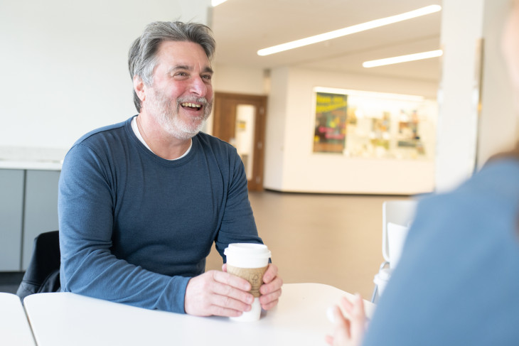 Harry Brown laughs at a table with student