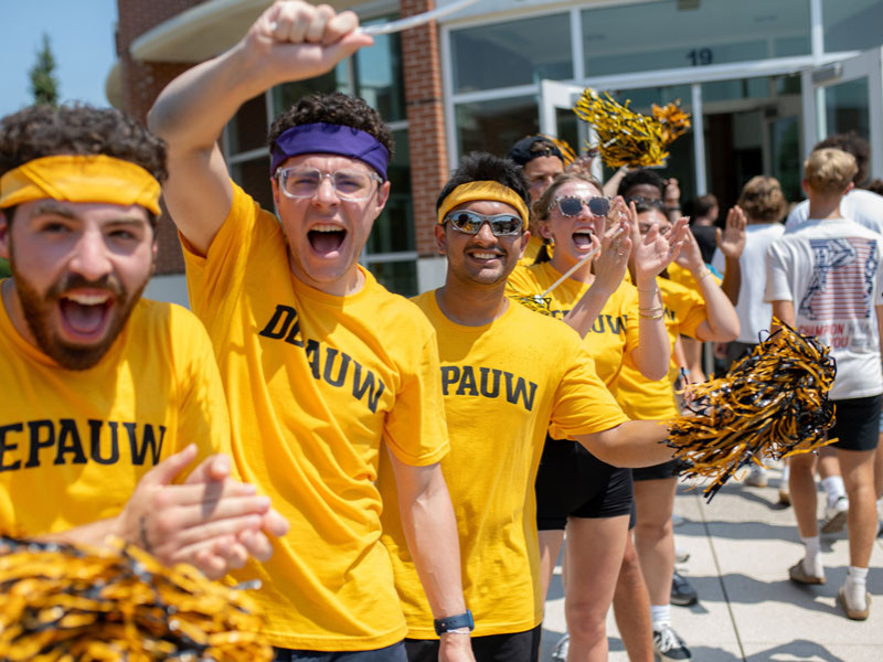 cheering students on steps in gold shirts
