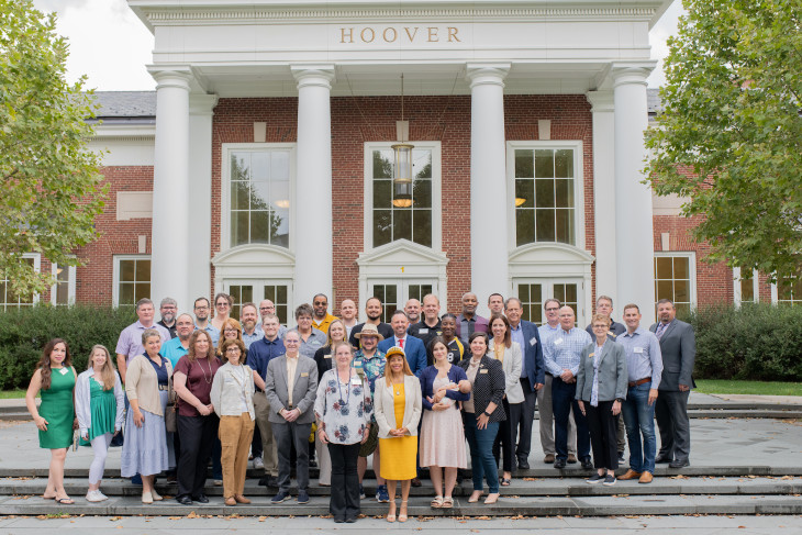 Group photo of attendees on steps of Hoover Hall