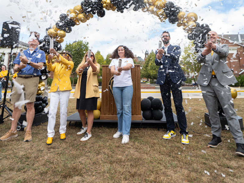 people celebrating at podium with confetti