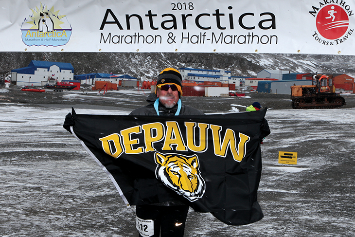 Luis Davila ’81 holds DePauw Tiger flag at the 2018 Antarctica marathon