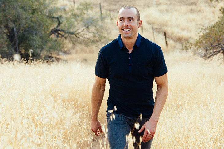 Jonathan Bailor ’05 walking in a field on a sunny day