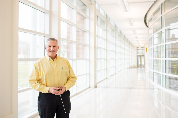 Smiling man in a hallway with glass windows