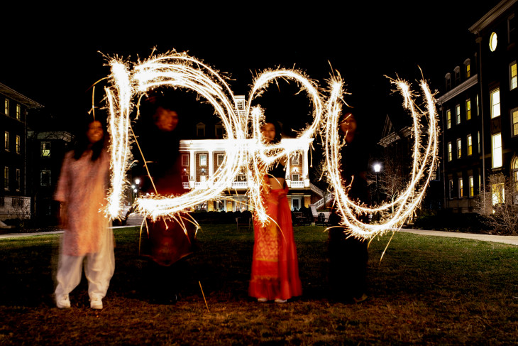 Students using light to spell "DPU" outdoors at night