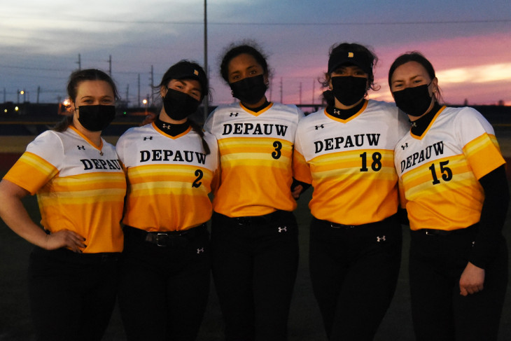 Masked softball players at dusk