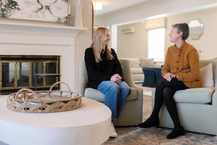 Student and alumnae talk while seated