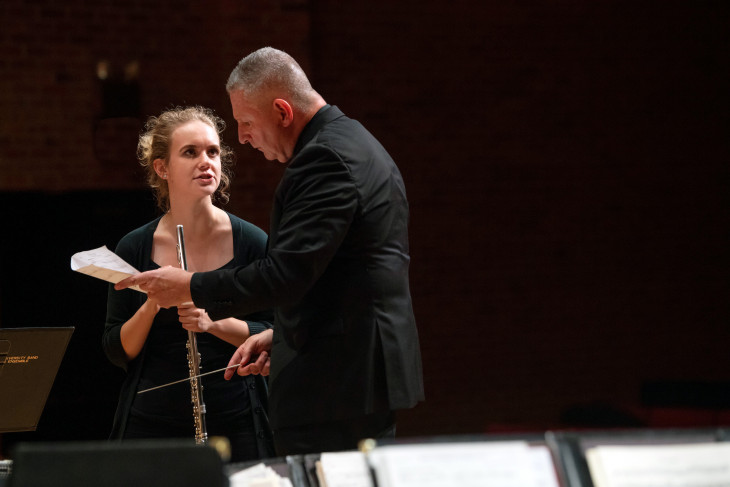 Conductor sharing notes with student musician