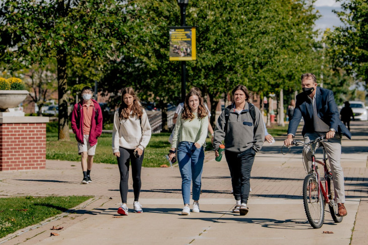 Students and a cyclist on campus