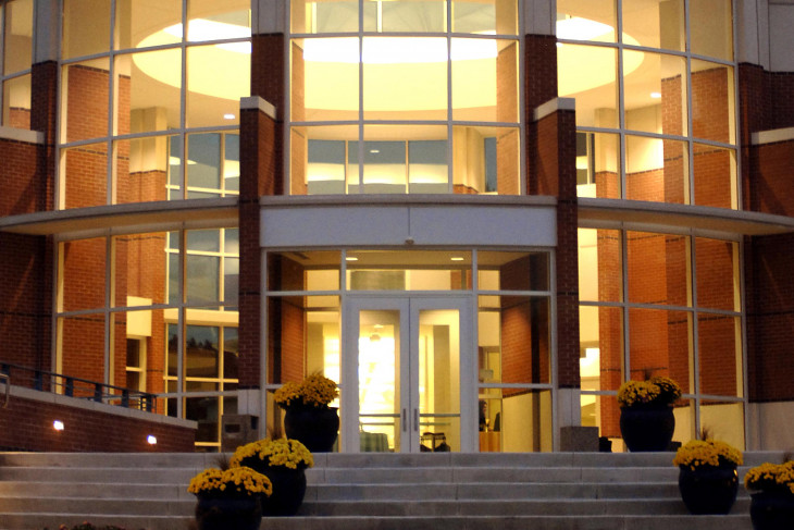 A building at dusk with a warm light inside