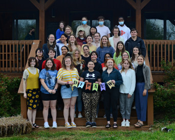 A group of students posing on the wooden front porch of the Ullem Center.