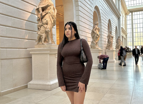 Vanessa standing in an art museum with sculptures behind her.