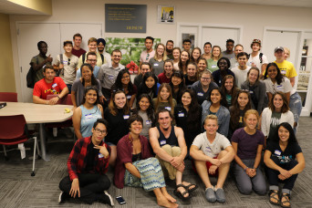 Students huddled together posing in a work area