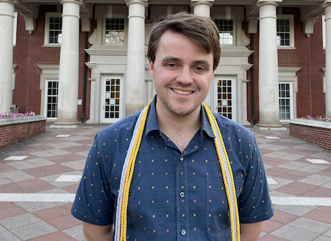 James Rueff smiling in front of Roy O. West