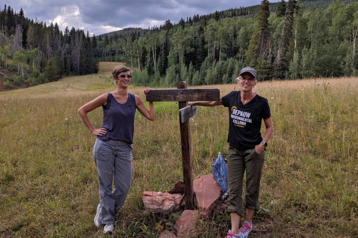 professors standing by a sign on a hike