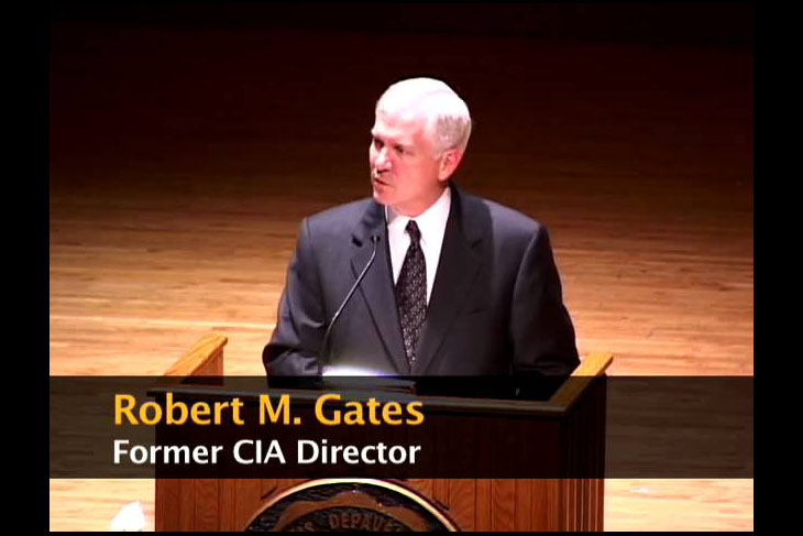 Robert Gates behind a lectern during an Ubben Lecture with name banner