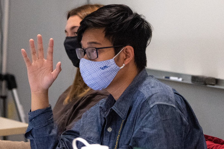 Ky Nguyen, a first-year student, raises his hand in class