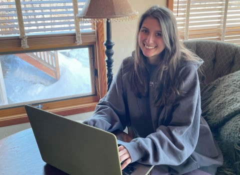 Margo Fox smiling while typing on her laptop