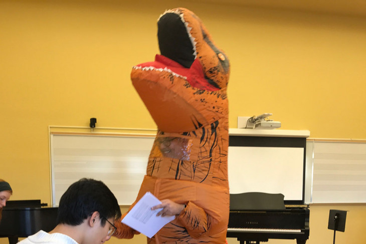 Professor in a dinosaur costume, teaching a class