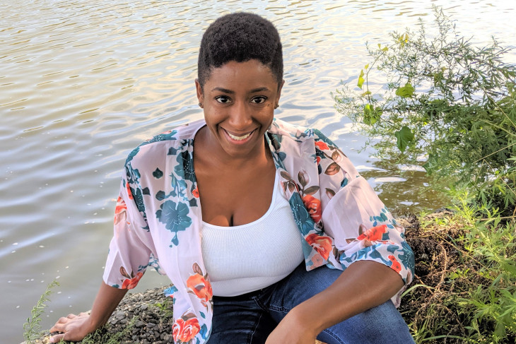 Social worker Anisah Miley poses on the bank of a pond 