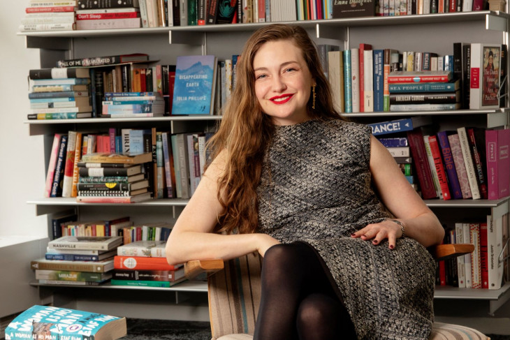 Erin Wick '11 sits before book-lined shelves