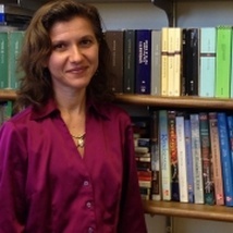 Francesca Seaman headshot with books in the background