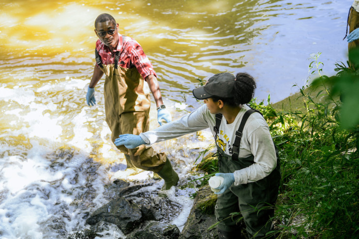 Amerti works with Phillips Akinwole in a local stream