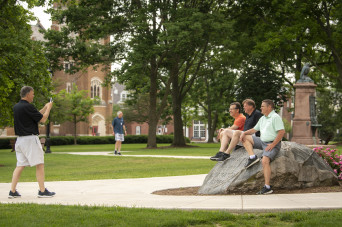 Alumni posing for a photo on the boulder