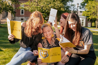 Students look through DePauw booklets while sitting 