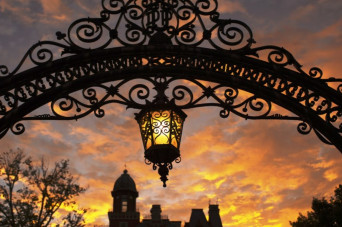 Arch with hanging lantern during sunset with East College backdrop