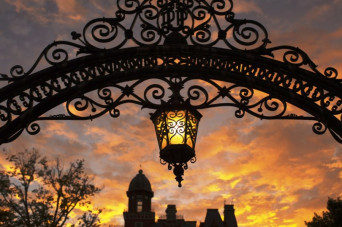 Arch with hanging lantern during sunset with East College backdrop